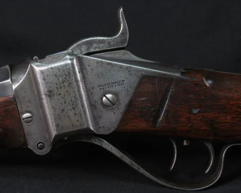 A close up photograph of the stock and trigger of an old rifle