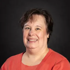 A short-haired white woman in an orange outfit